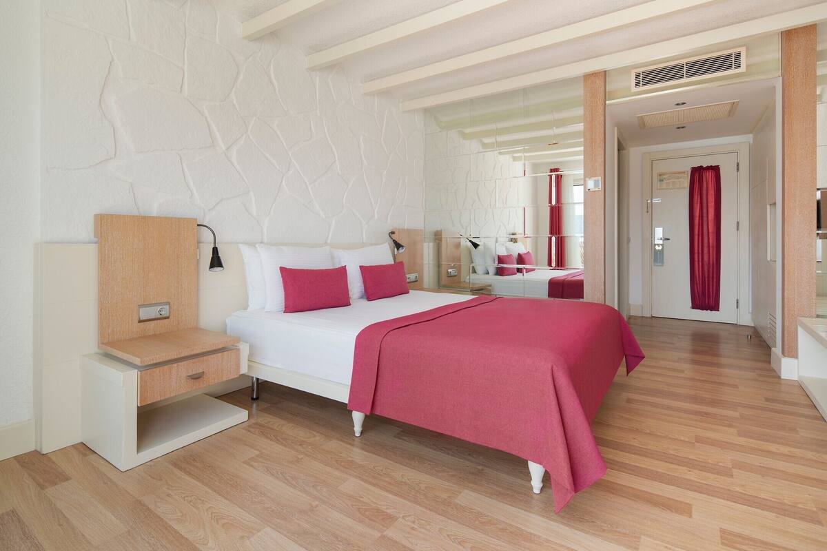 Une chambre à coucher moderne avec un lit, une table de chevet et un miroir.