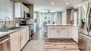 A modern kitchen with white cabinetry, stainless steel appliances, and a central island. - Elegant home in the heart of Westfield! Perfect for family gatherings! (Westfield)