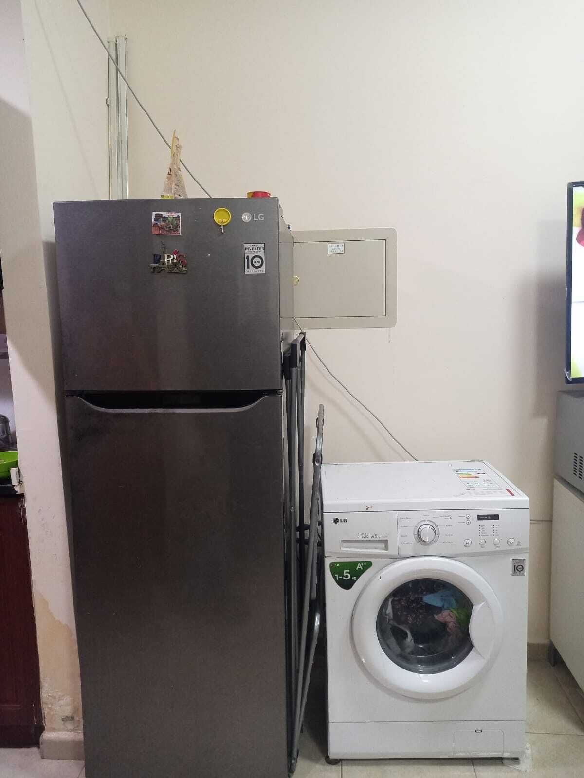 Een kleine keuken met een koelkast en een wasmachine.
