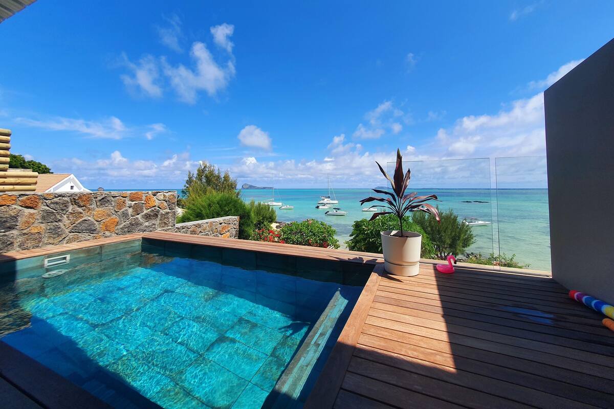 A swimming pool with a view of the sea and boats.