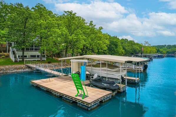 A floating dock with a covered seating area, a small boat, and a pool. - The Kelley's Lakefront Escape LOTO (Sunrise Beach)