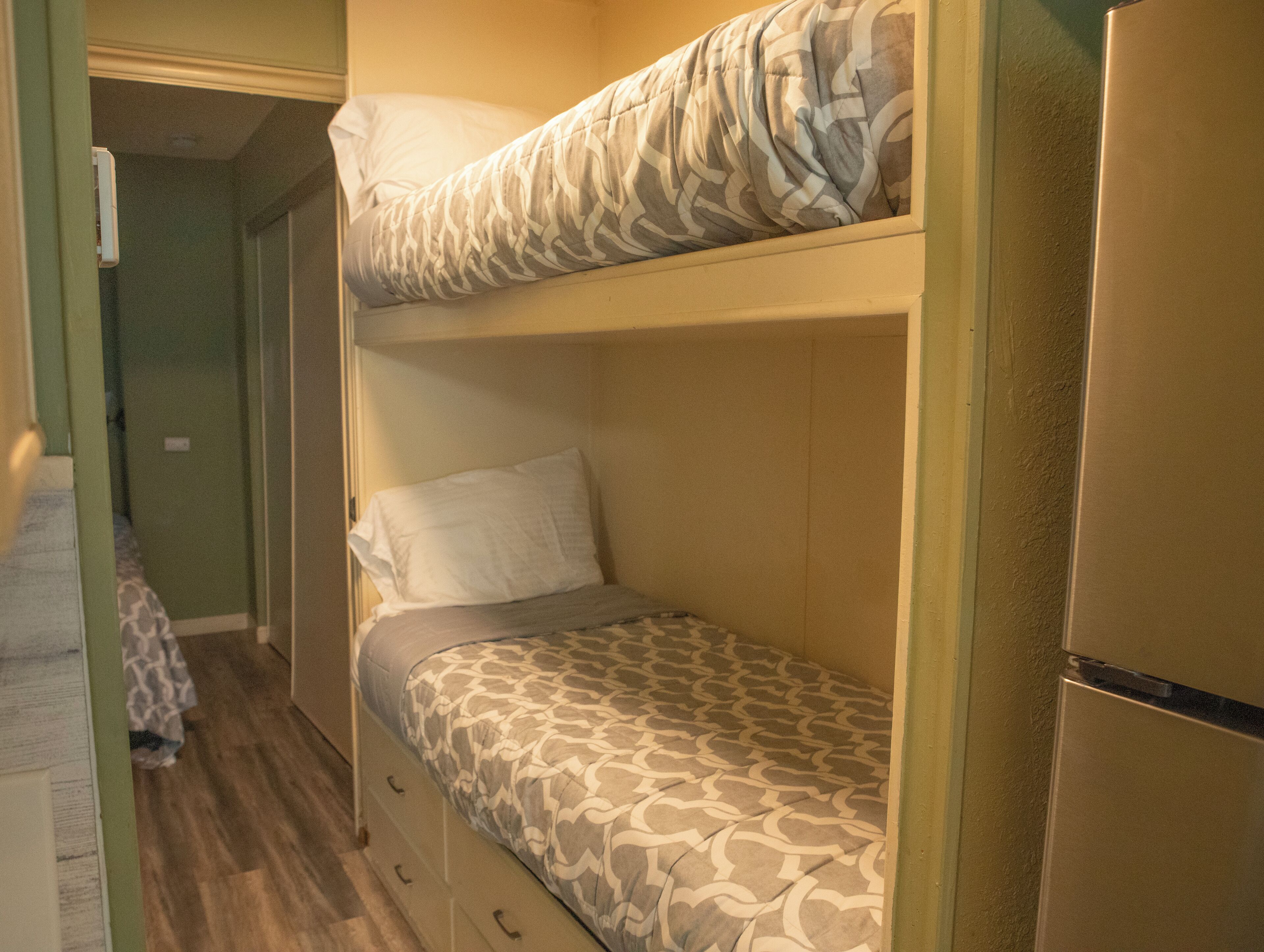 Habitación con literas, un edredón estampado y una almohada lisa.