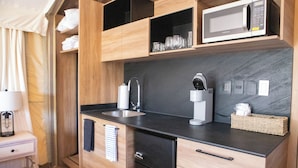 Une cuisine moderne avec un plan de travail noir, des meubles en bois, un four à micro-ondes et une machine à café.