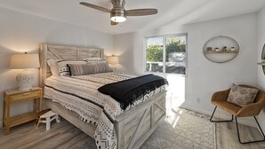 A bedroom with a bed, bedside tables, a chair, a ceiling fan, and a window with blinds. - Forest Heights ~ Relaxed Modern-Boho Style, Forest Views, Hot Tub, Wine Country (Forestville)