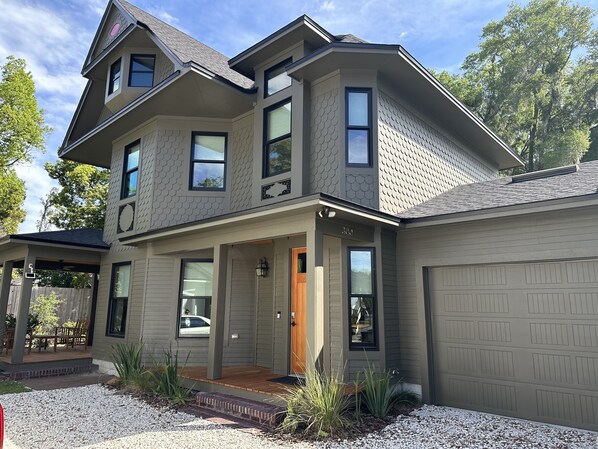 A two-story house with a garage, a covered porch, and a front door.