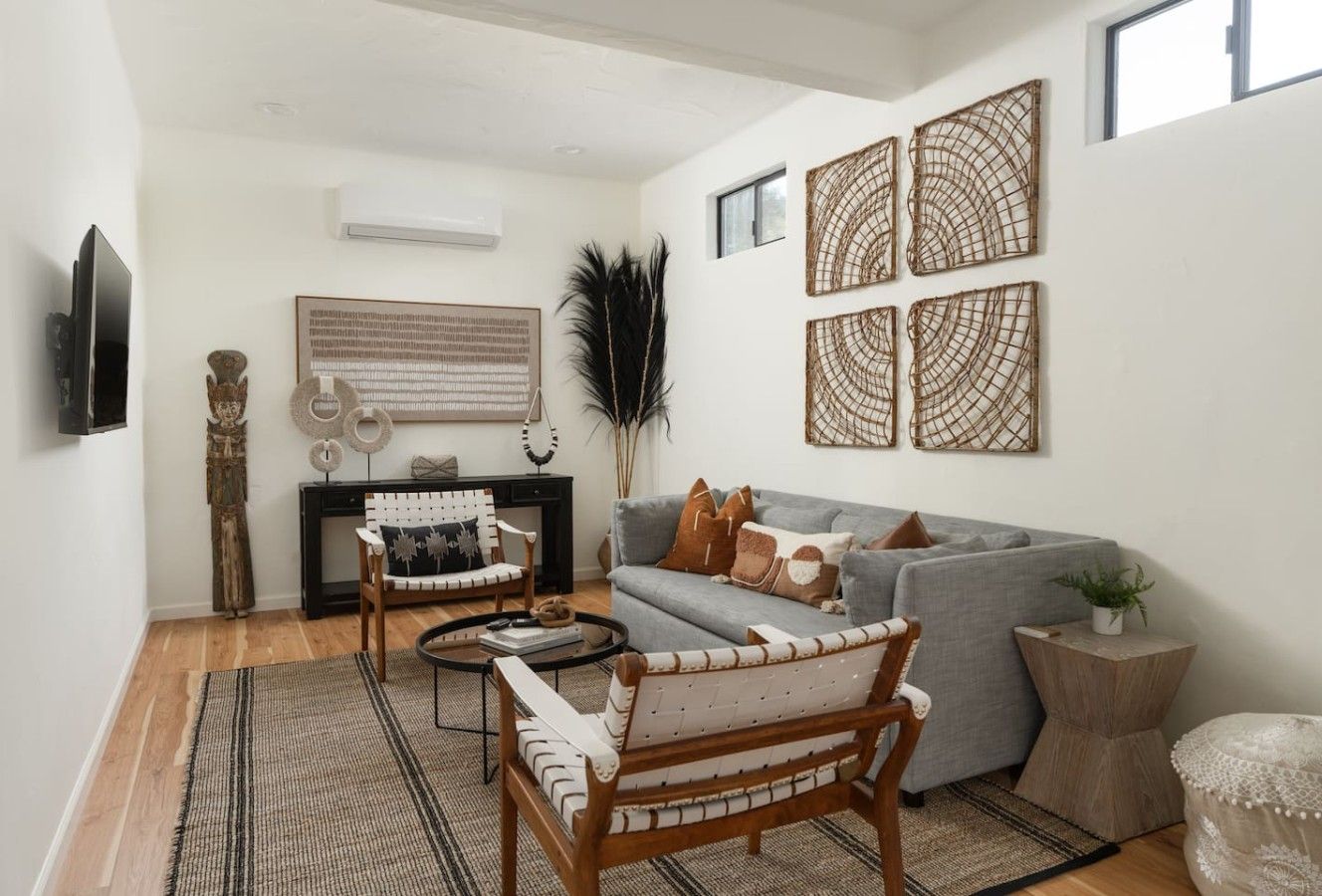 A living room with a grey sofa, a wooden chair, a coffee table, and a fireplace.