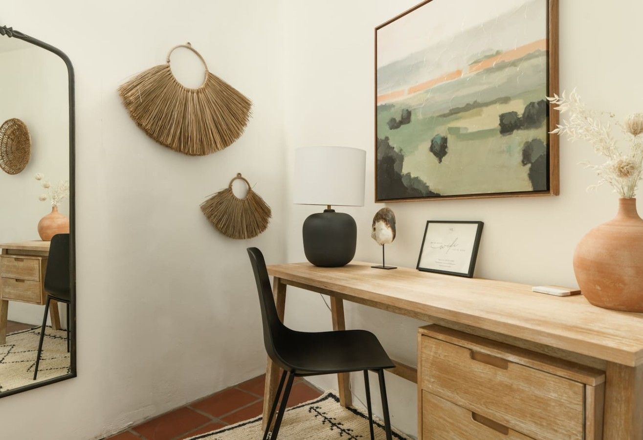 A modern office space with a desk, chair, and wall-mounted decor.