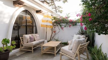 Un espacio al aire libre con sofás, sillas y una mesa de centro.