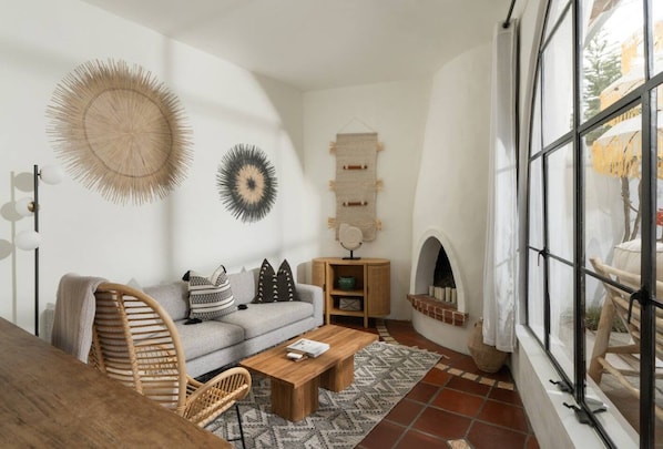 Una sala de estar con sofá, mesa de centro y decoración en la pared.