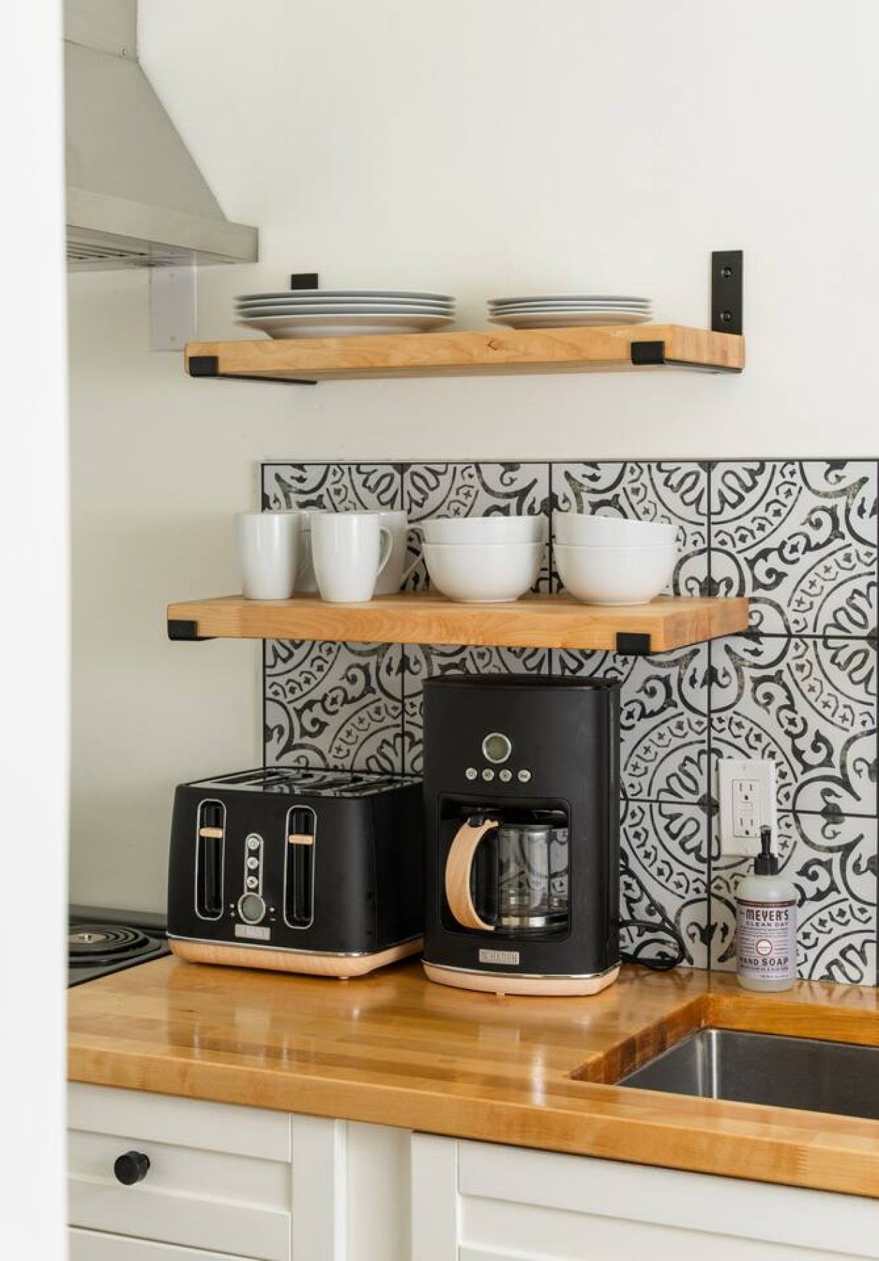 A kitchen with a toaster, a coffee maker, and a sink.