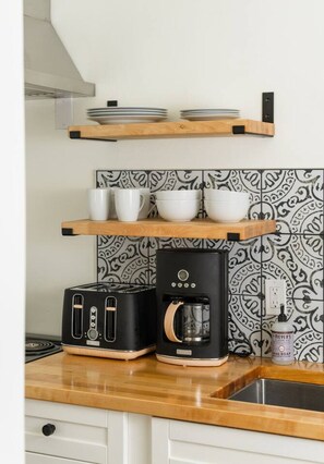 Une cuisine équipée d’un grille-pain, d’une machine à café et d’un évier.