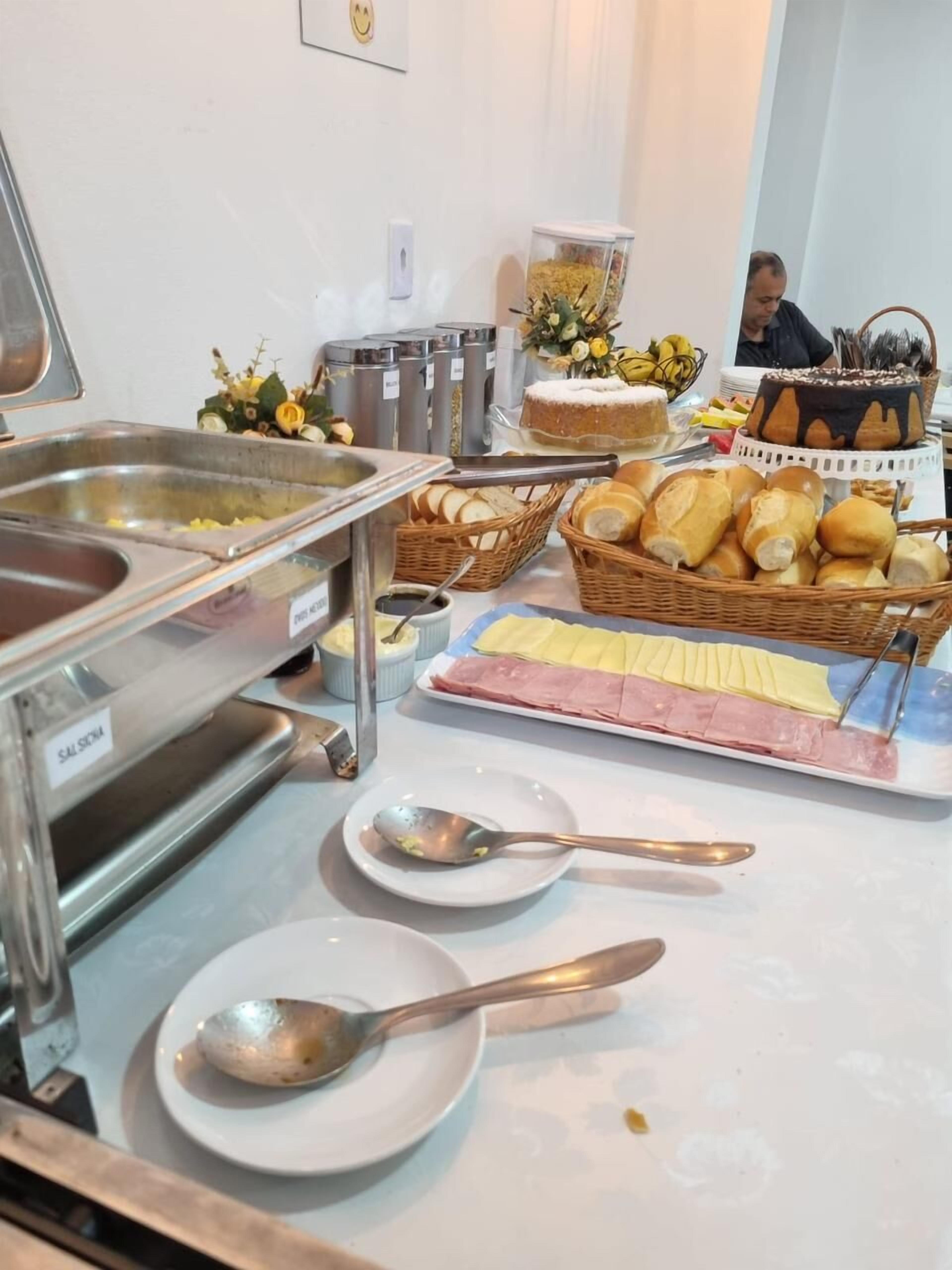 A buffet setup with various food items, including bread, cheese, and meats.