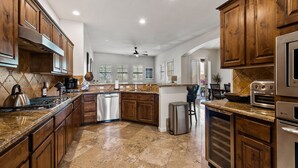 A spacious kitchen with wooden cabinets, granite countertops, and stainless steel appliances.