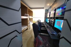 A room with bunk beds, a desk with multiple computers, and a window with a view. - Ningdu Hotel (Anyue)