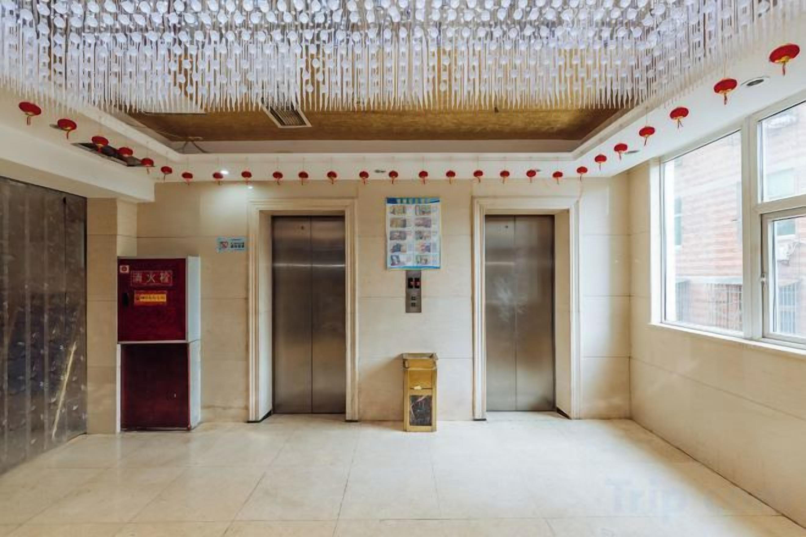 A lobby with elevators, a vending machine, and a bulletin board.