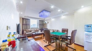 Habitación de hotel con mesa de billar, sofá, televisor y minibar.