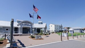 Un bâtiment abritant la mairie, sur lequel on peut lire l’inscription « Ville de Kure Beach », avec un mât où flottent plusieurs drapeaux, une zone d’entrée pavée et un bâtiment doté d’un toit en métal.