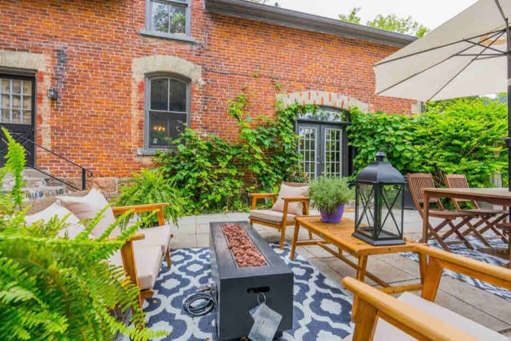 A brick building with a patio area featuring outdoor furniture, a fire pit, and a lantern.