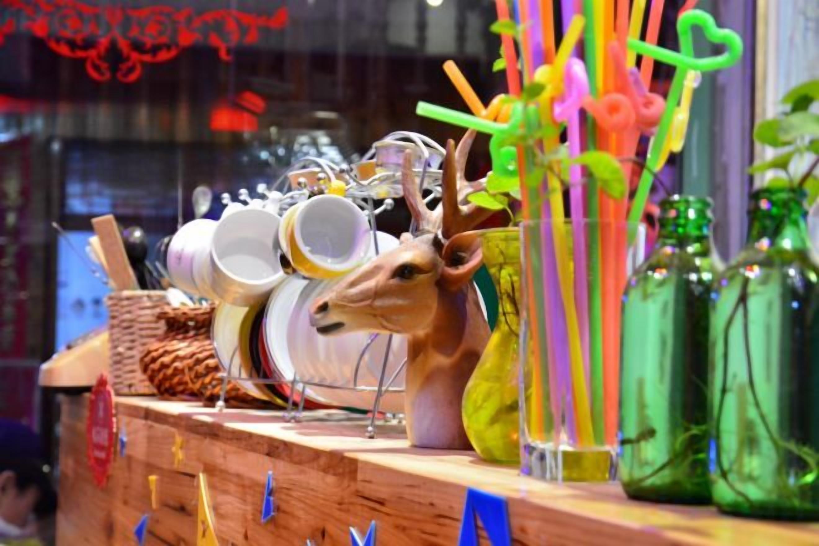 A display with various items including a deer head, plates, and bottles.
