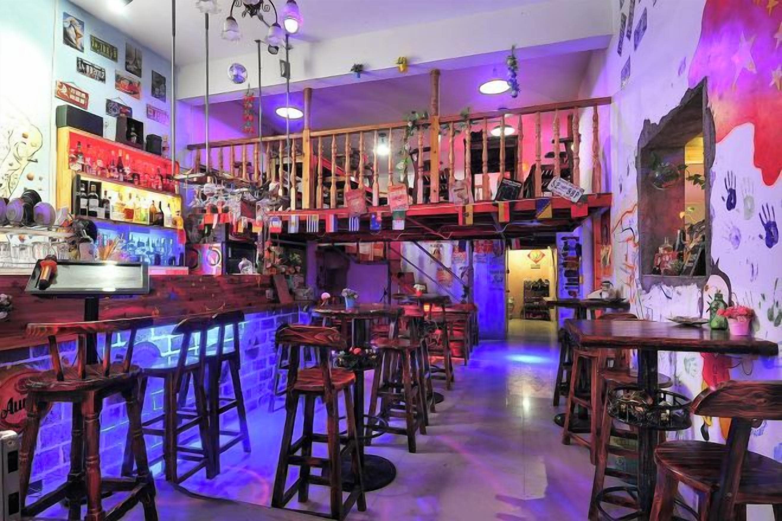 Eine Bar mit Barhocker, einer Theke und einer Treppe zu einer erhöhten Ebene.