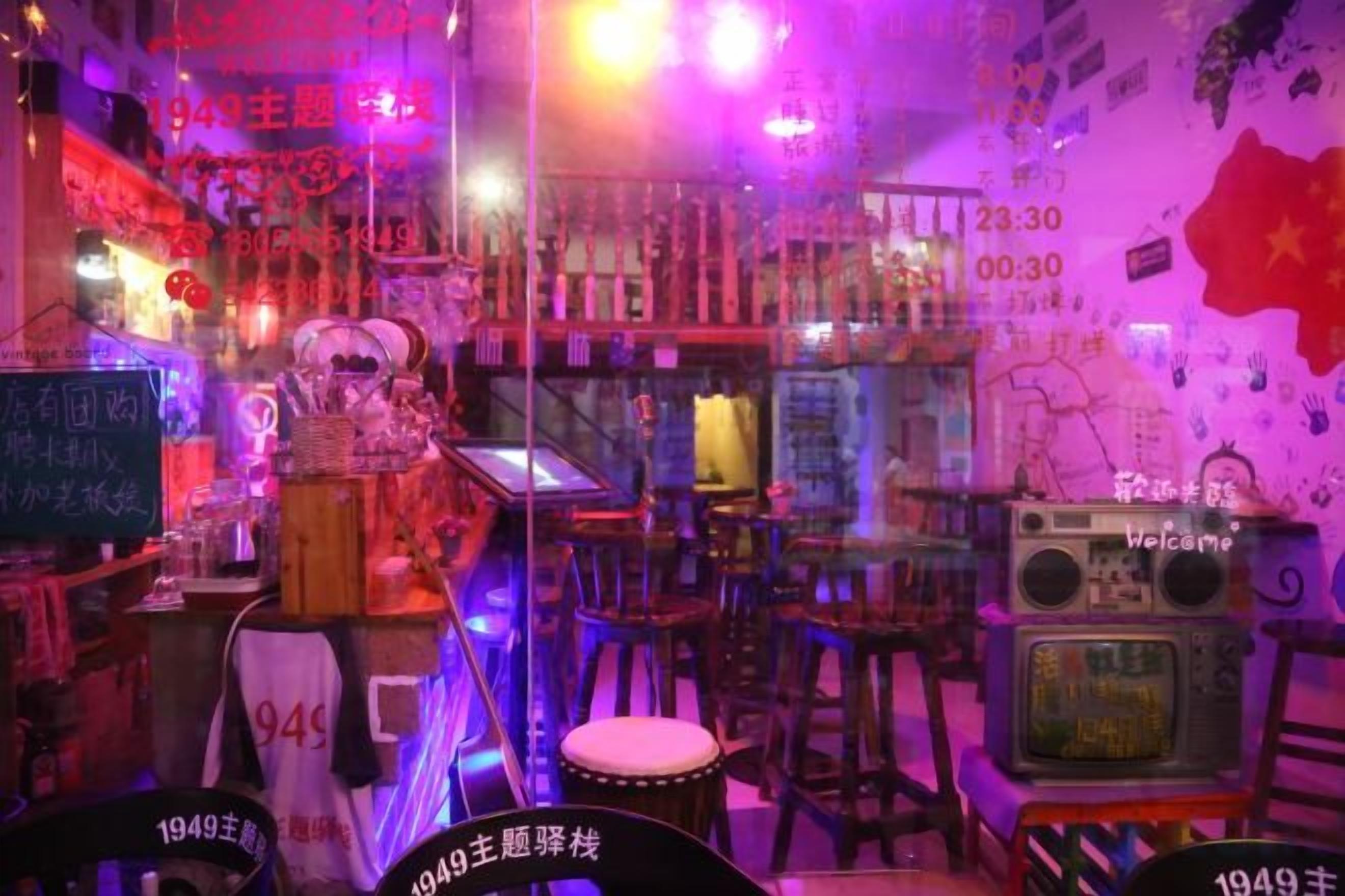 Una habitación con temática vintage, que incluye una radio de 1949, una pizarra con escritura y una pared con una bandera roja.