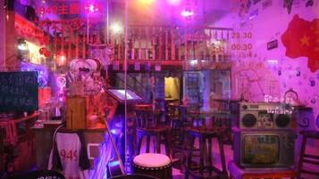 Una habitación con temática vintage, que incluye una radio de 1949, una pizarra con escritura y una pared con una bandera roja.