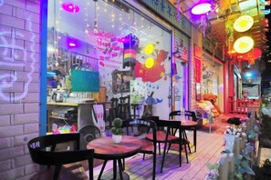 An indoor seating area with tables and chairs, a counter with a menu, and a wall with a map and text. - Nanjing Qingjian 1949 Bed and Breakfast (Yunshuiyao Scenic Area Branch) (Nanjing County)