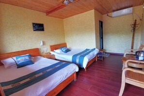 A room with two beds, wooden furniture, and a red floor.