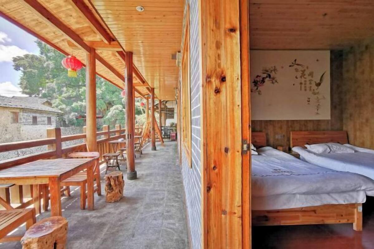 A wooden room with a bed, a wooden table, and a bench.