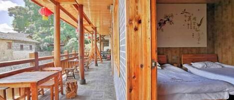Una habitación de madera con una cama, una mesa de madera y un banco.