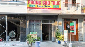 Un edificio con un cartel que indica un hotel y un motel, con información de contacto y horario de atención.