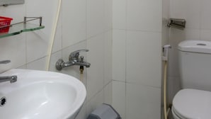 A bathroom with a white sink, a toilet, and a shower with a hose. - Ngoc Trinh Hotel Binh Tan by Zuzu (Ho Chi Minh Municipality)