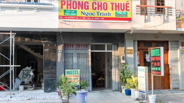 A building with a sign for a hotel and a motel, indicating 24/7 availability. - Ngoc Trinh Hotel Binh Tan by Zuzu (Ho Chi Minh Municipality)