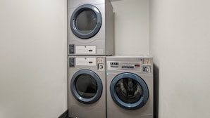 A laundry room with two stacked front-loading washing machines. - Red Roof Inn PLUS+ Belleville (Belleville)