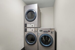 A laundry room with two stacked front-loading washing machines. - Red Roof Inn PLUS+ Belleville (Belleville)