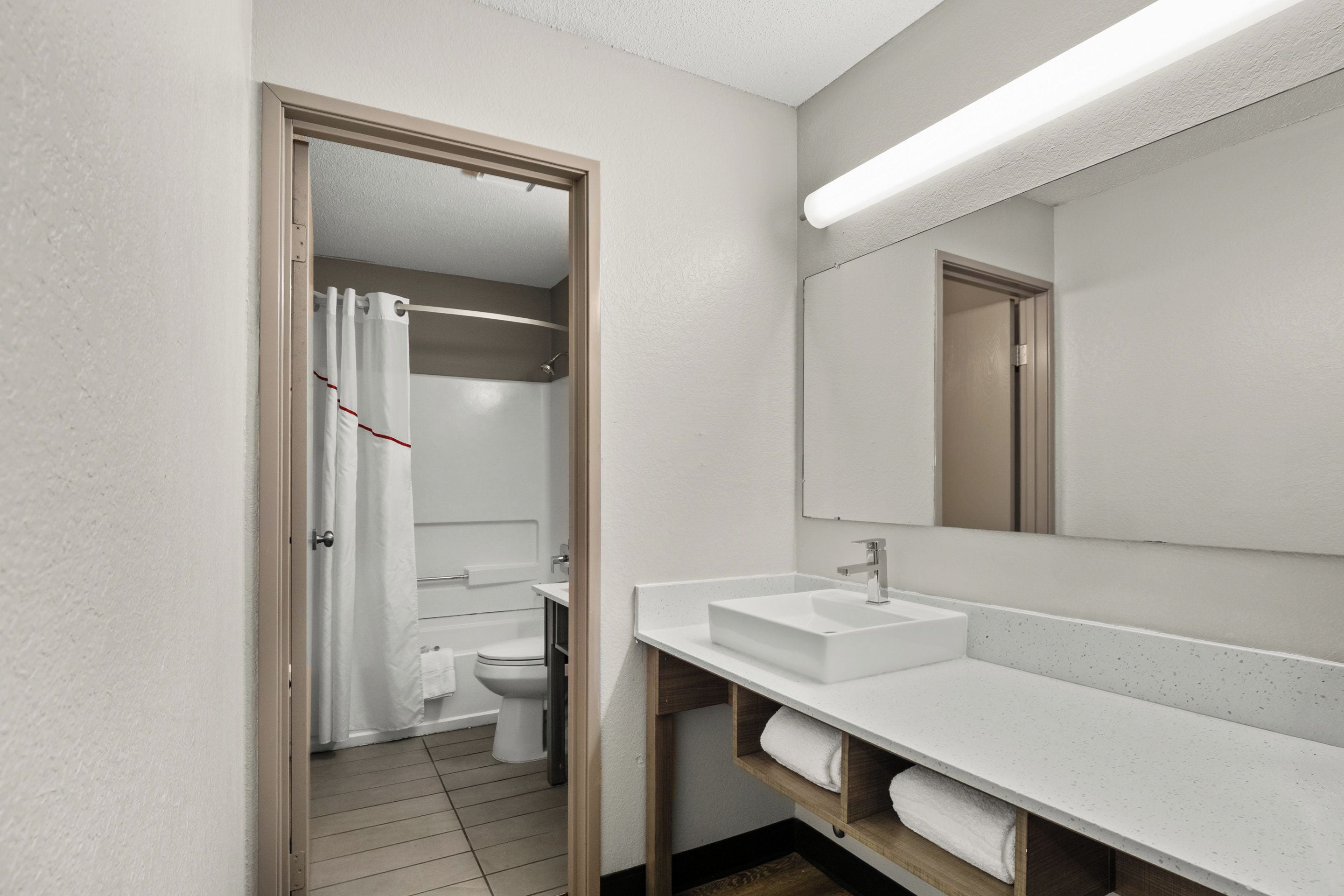 A modern bathroom with a shower, toilet, and sink.