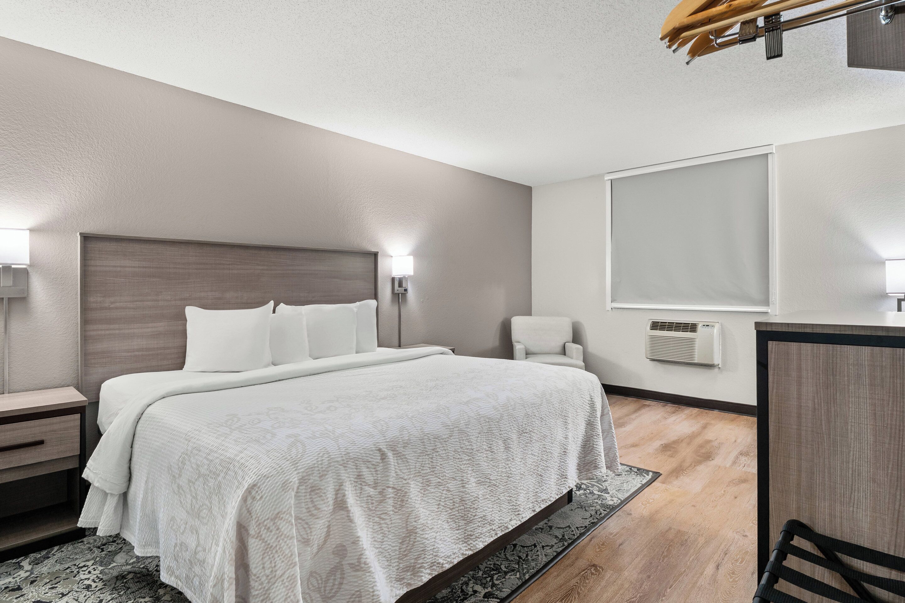 Une chambre d’hôtel moderne avec un grand lit, des tables de chevet, un bureau et une chaise.
