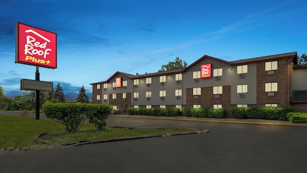 A Red Roof Plus hotel with a brick facade, multiple windows, and a well-maintained lawn. - Red Roof Inn PLUS+ Belleville (Belleville)