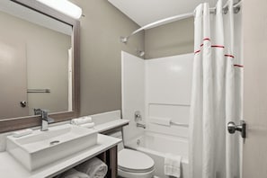 A modern bathroom with a sink, mirror, toilet, and bathtub. - Red Roof Inn PLUS+ Belleville (Belleville)