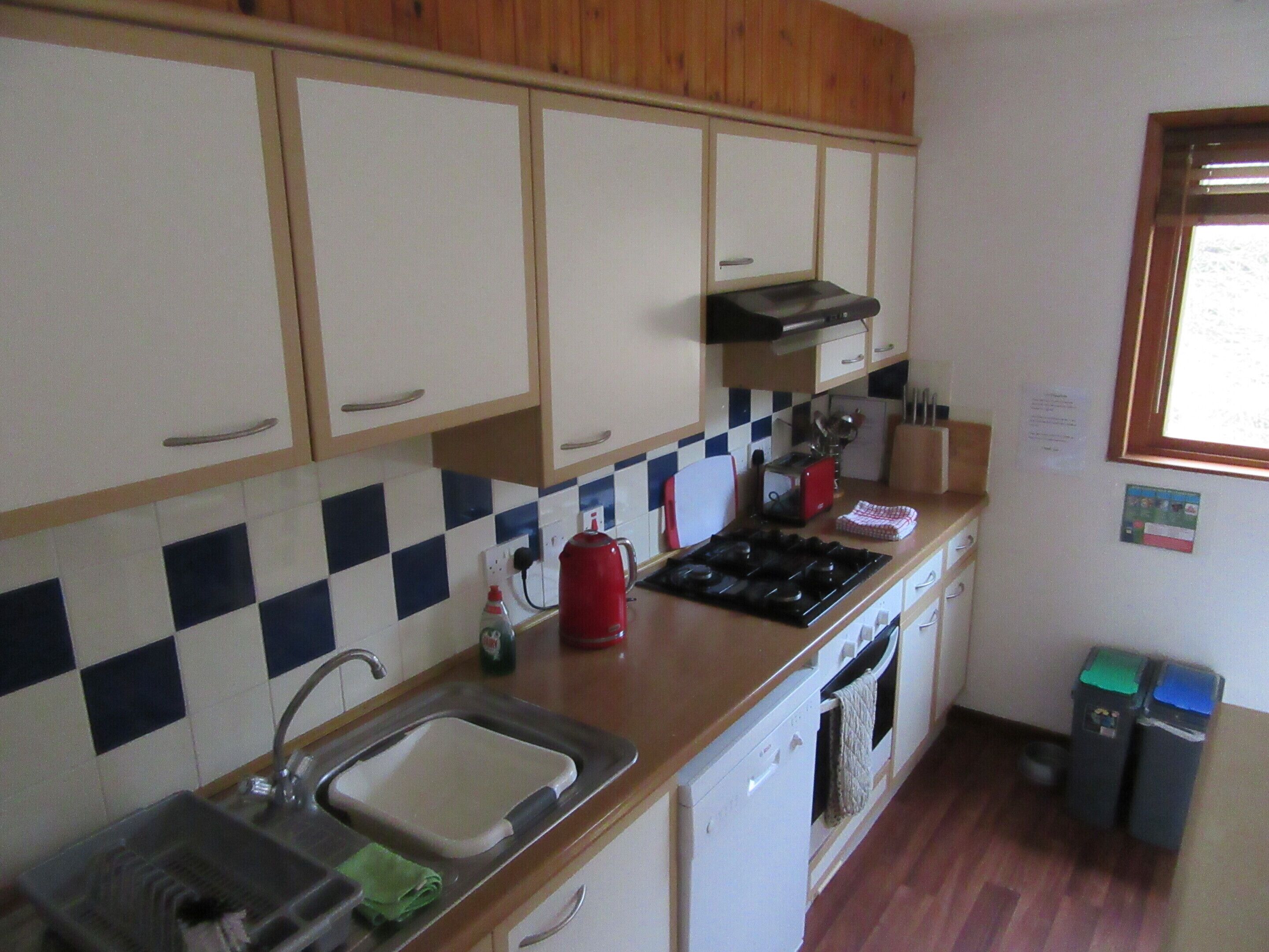A kitchen with a sink, stove, and cabinets.