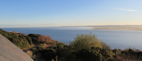 Vista costera con una terraza de madera que da al mar.