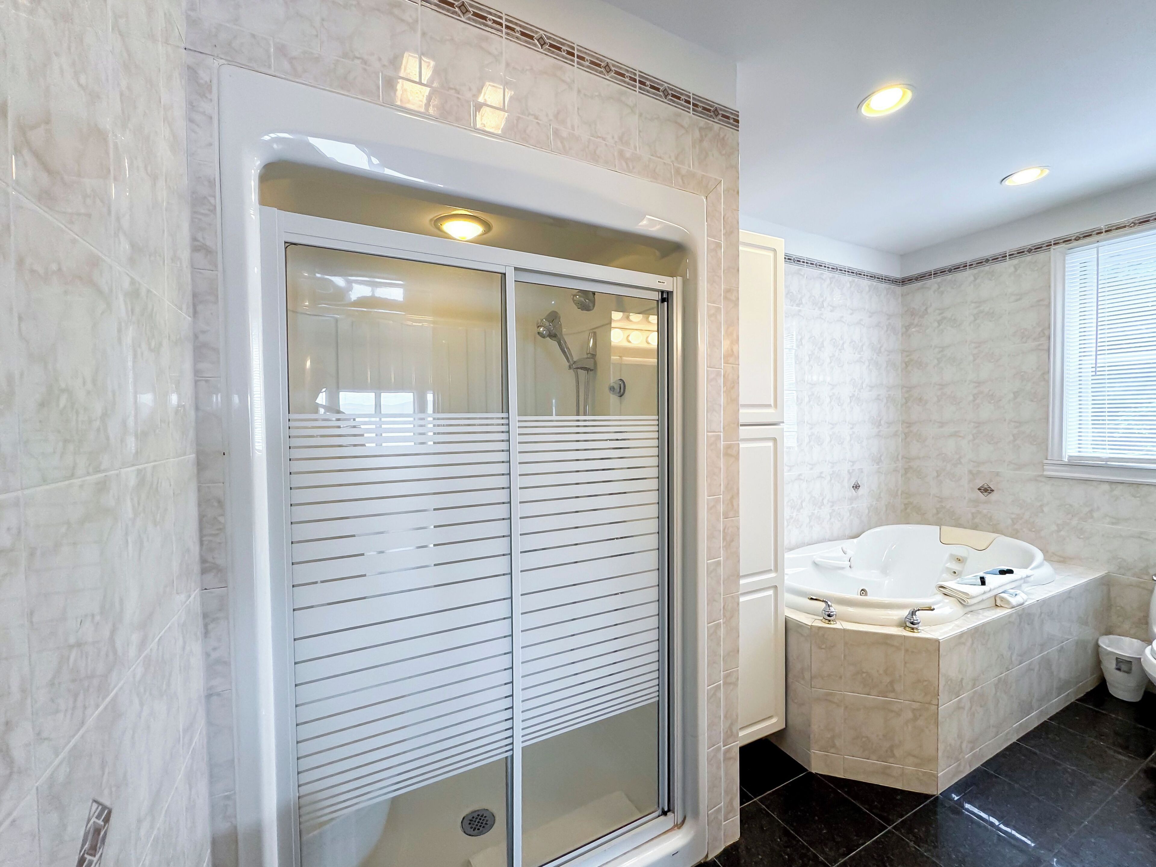 A modern bathroom with a glass-enclosed shower, a freestanding bathtub, and a vanity with a sink.