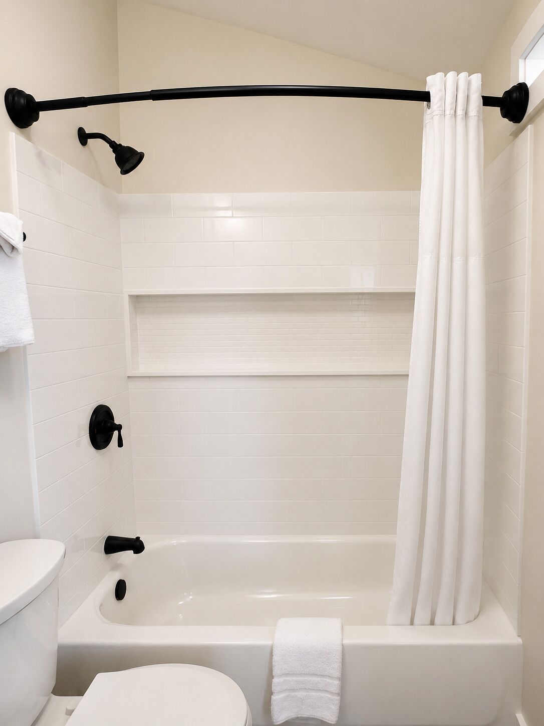 Een badkamer met een bad, toilet en een douche.
