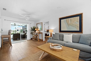 A spacious living area with a wooden coffee table, a grey sofa, and a large framed map on the wall. - " BRING YOUR BOAT!!! Enjoy easy access NEW dock, Pool & more! (Naples)