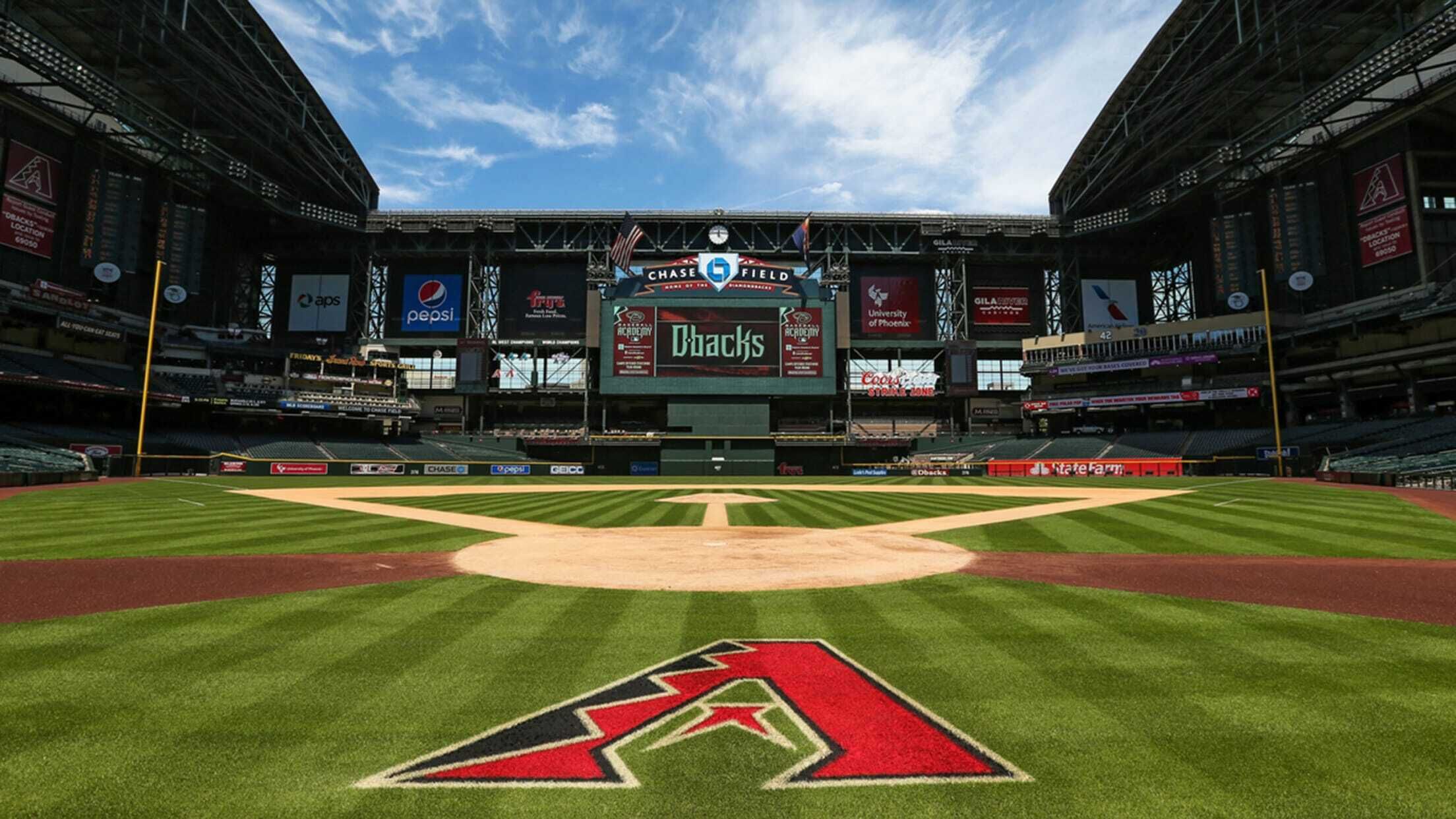 A baseball stadium with a large scoreboard, advertisements, and a well-maintained field.