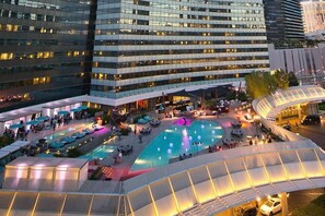 Un hôtel doté d’une piscine sur le toit, d’un espace extérieur aménagé et dont le bâtiment principal est une structure moderne en verre.
