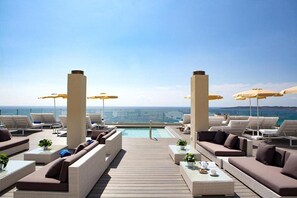 A rooftop lounge with sun loungers, umbrellas, and a pool. - Hotel Sabina Playa Adults Only Hotel (Son Servera)