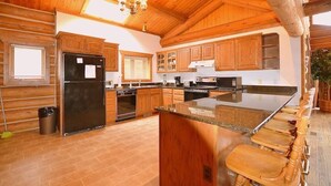 A spacious kitchen with wooden cabinets, a large island, and a built-in oven.