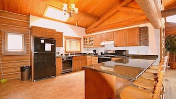 Une cuisine spacieuse avec des meubles en bois, un grand îlot central et un four encastré.