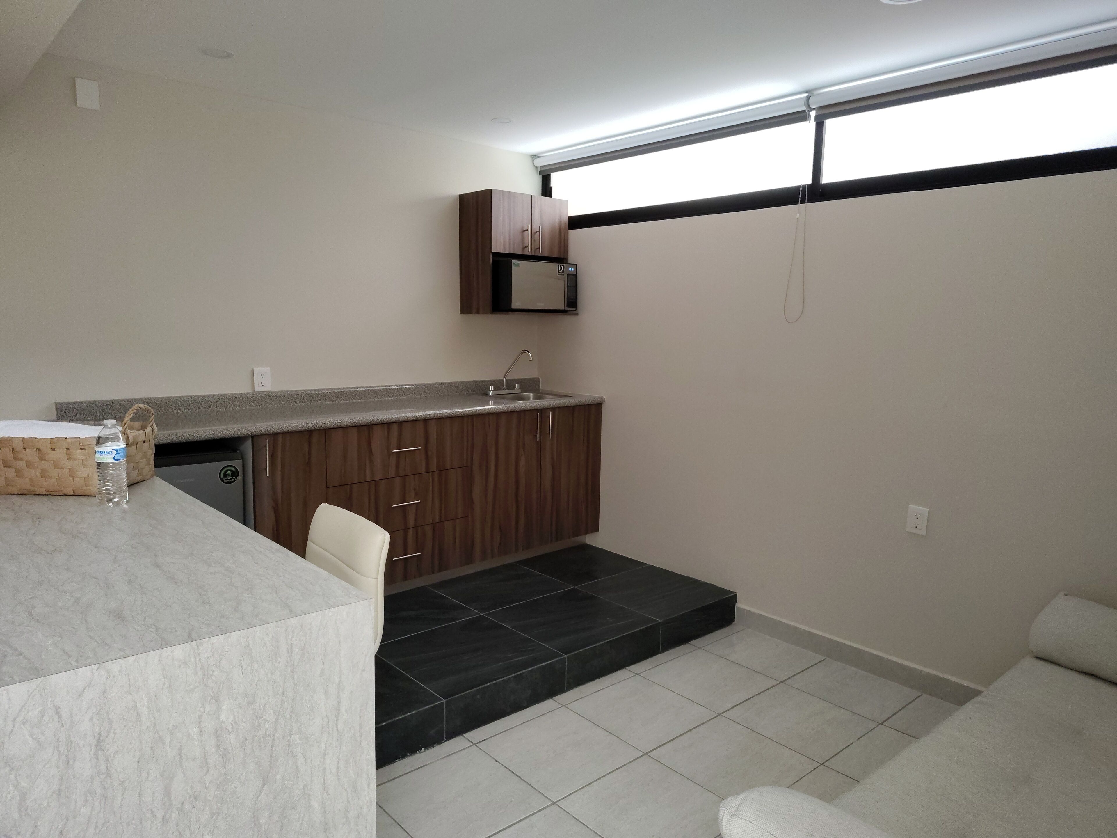 A compact kitchen with dark wooden cabinets, a built-in sink, and a countertop.